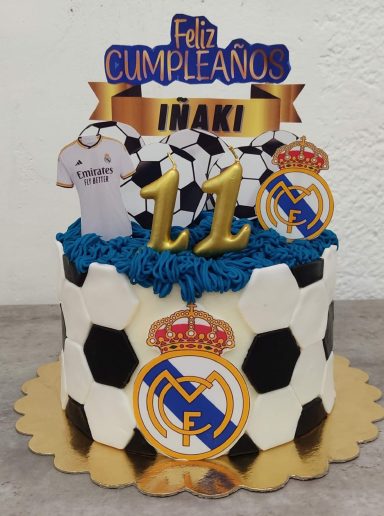 Pastel de cumpleaños con temática de fútbol, decorado con el logo del Real Madrid y el número 11.